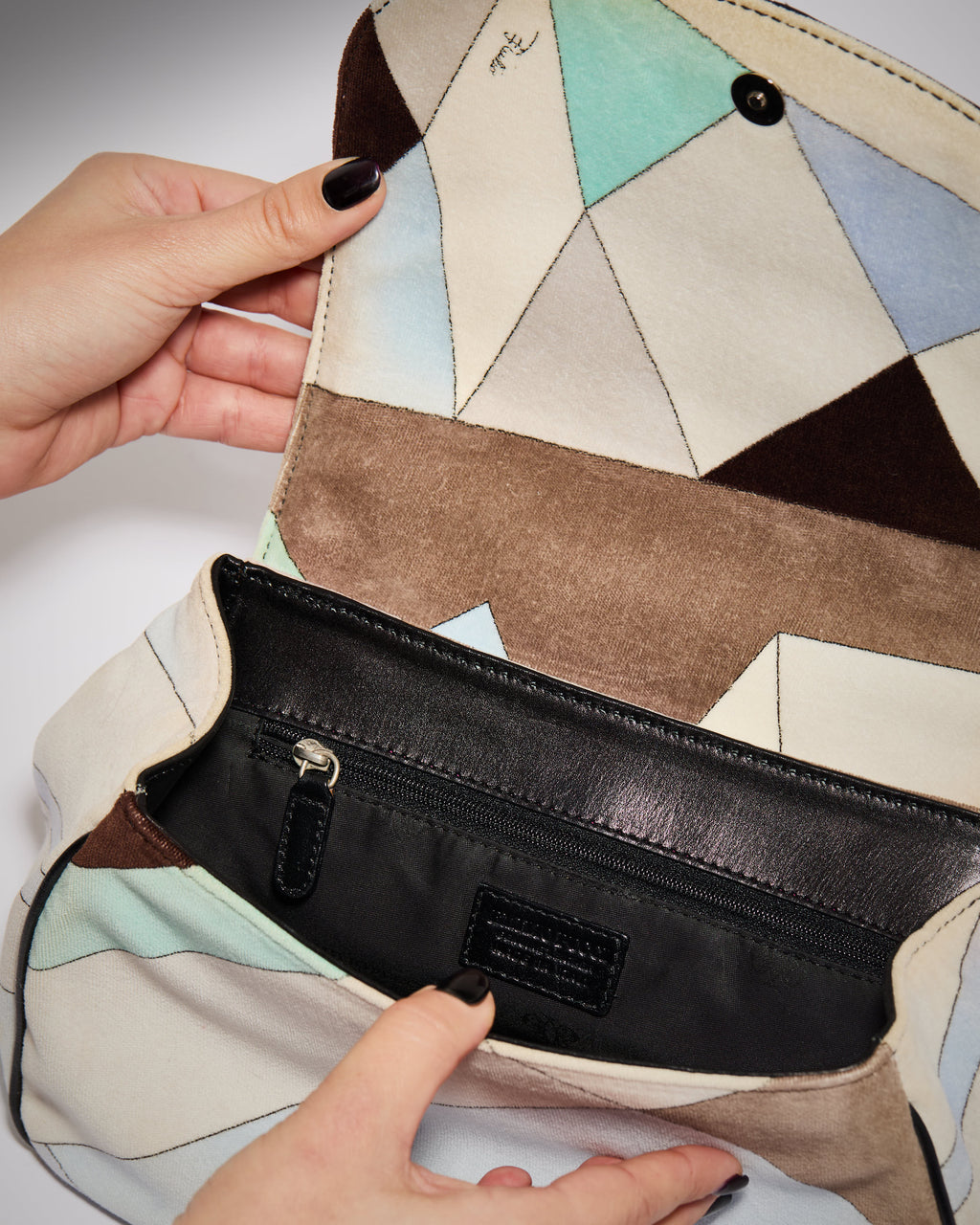 Interior of vintage Pucci velvet handbag with fabric lining and zip pocket
